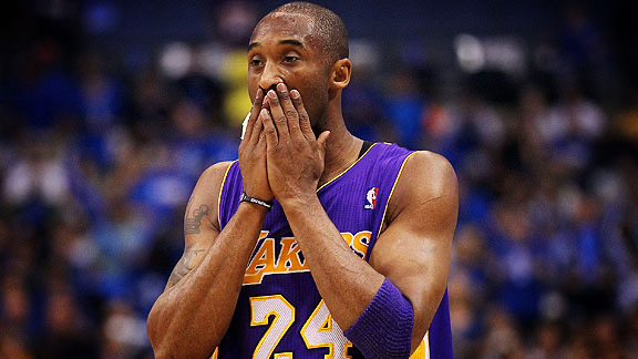 Kobe Bryant in a Lakers number 24 jersey with his hands raised to his face during a game